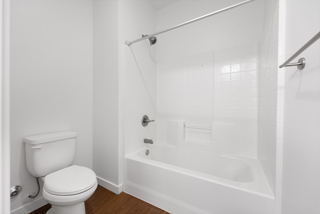 A white toilet is next to a white bathtub in a bathroom.